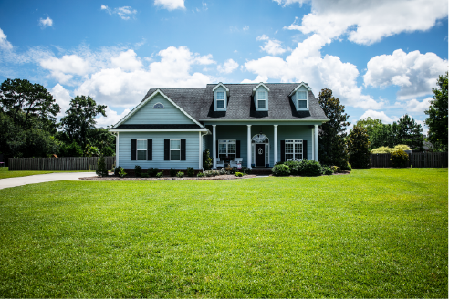 pale blue house with siding on a large lot with traditional windows and shutters in a subdivision in the suburbs on a bright sunny blue sky day | Advanced Heating and Air Conditioning